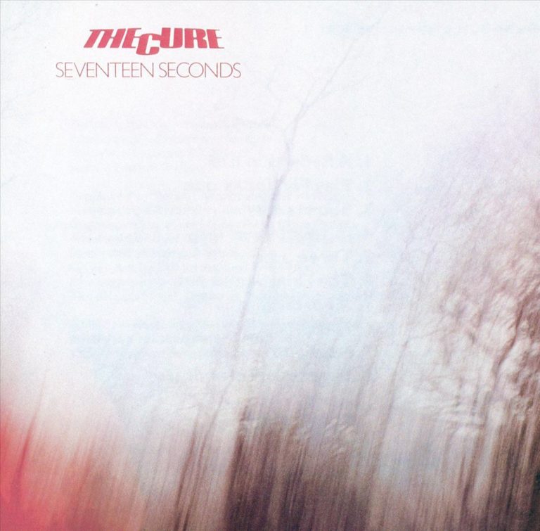 Albumcover von The Cure mit verschwommenem, hellen Hintergrund und rotem Schriftzug.