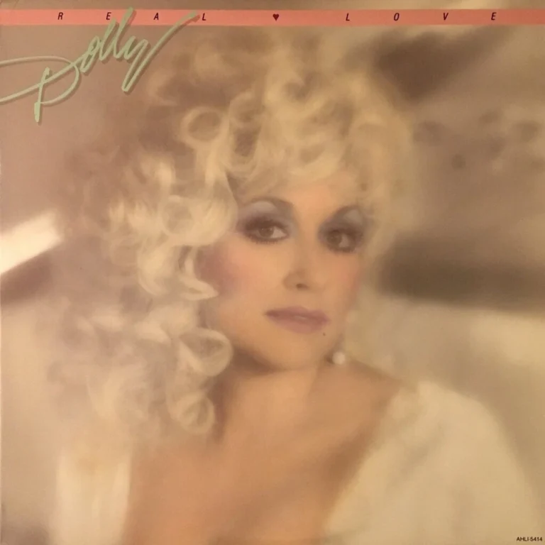 Dolly Parton mit lockigem, blondem Haar und dramatischem Make-up auf dem Cover ihres Albums Real Love.