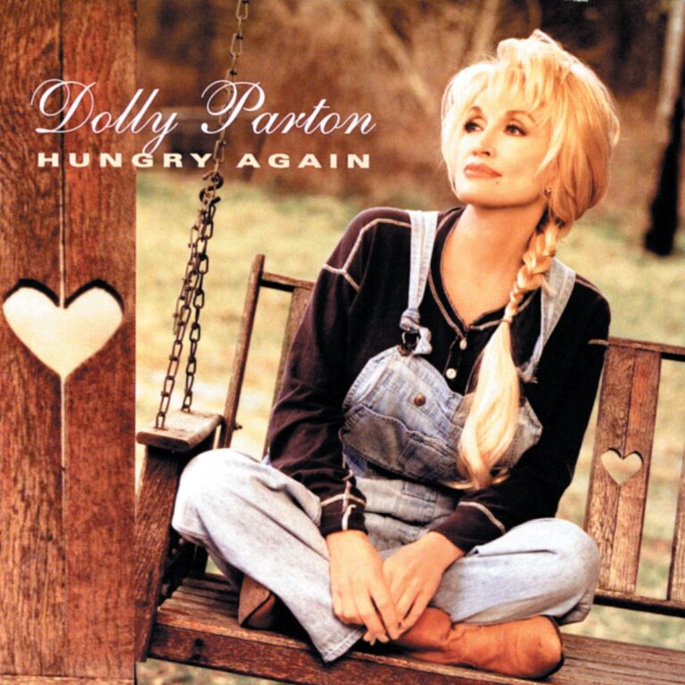 Dolly Parton sitzt in Latzhose auf einer Holzschaukel mit Herzmotiv.