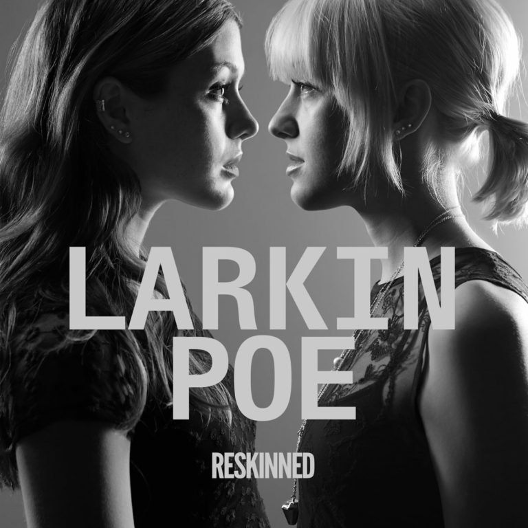 Zwei Frauen im Profil blicken sich an, vor grauem Hintergrund mit dem Schriftzug Larkin Poe Reskinned.