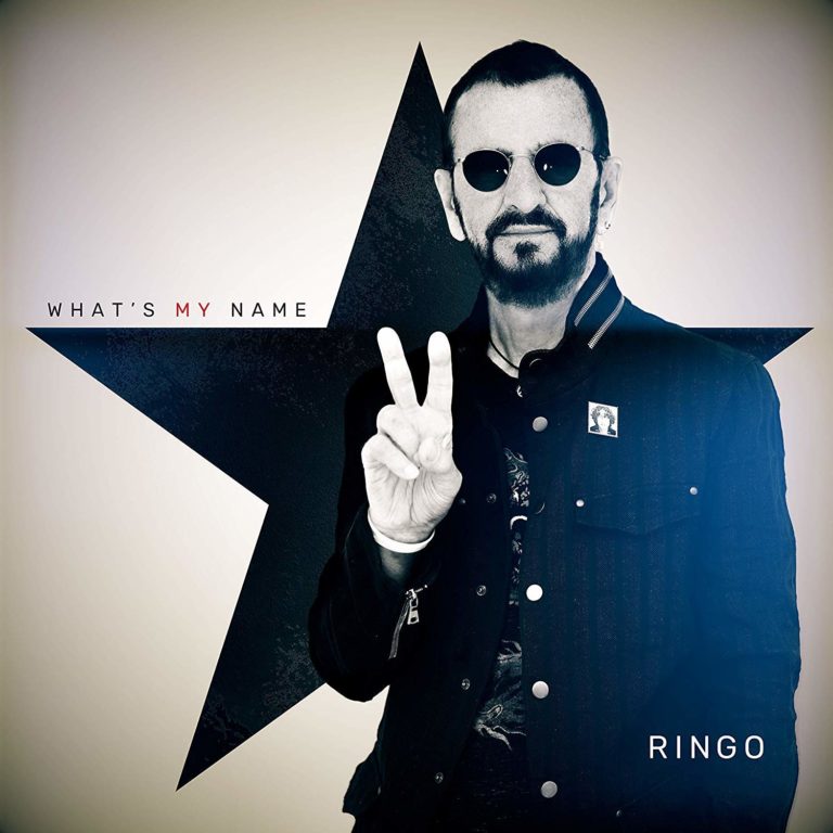 Ringo Starr zeigt das Peace-Zeichen vor einem großen schwarzen Stern.