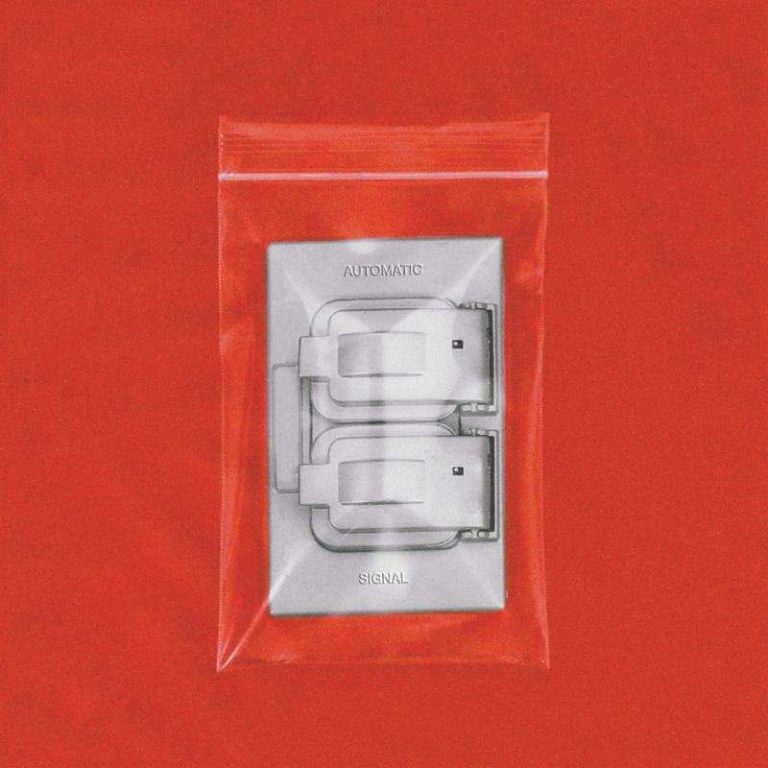 Rotes Cover mit silbernem Doppelschalter in transparenter Plastikhülle.