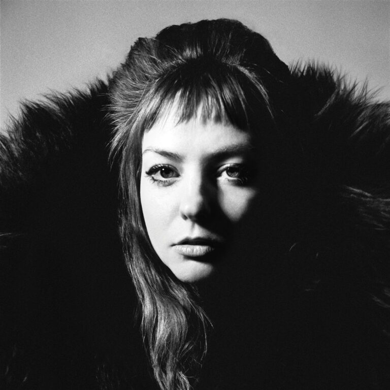 Schwarz-weißes Albumcover von Angel Olsen „All Mirrors“: Nahaufnahme ihres Gesichts, umrahmt von dunklem Fell, halb im Schatten, halb im Licht.