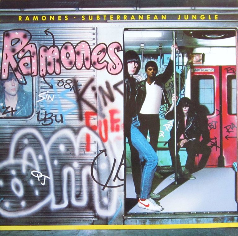 Die Ramones posieren in einer U-Bahn mit Graffiti, umgeben von urbanem Flair und einem Hauch von Punk-Ästhetik.