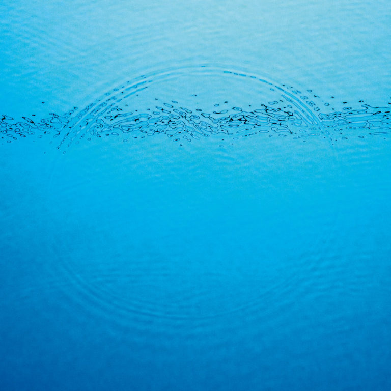Blaues Wasser mit konzentrischen Kreisen und Wellenmuster auf dem Coverbild.