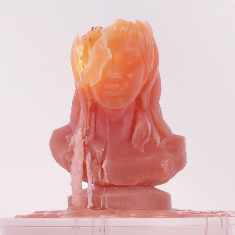 Ein schmelzender Wachskopf in Form einer Büste von Kesha, teils entstellt, symbolisiert das Album High Road mit seinem Mix aus Verletzlichkeit und Ironie.