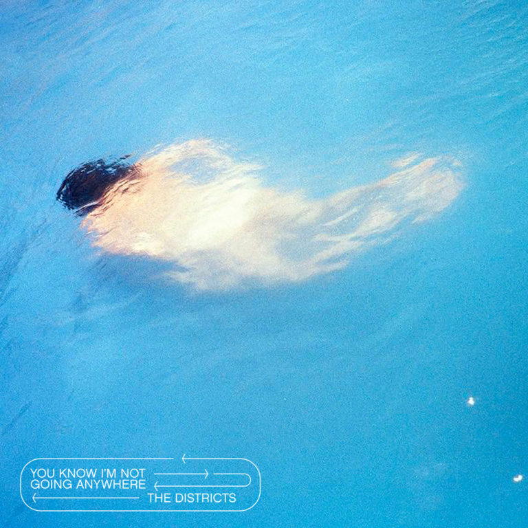 Verschwommene Unterwasseraufnahme einer Person in blauem Wasser.