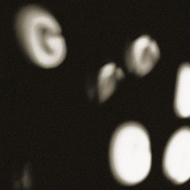 Unscharfe, weiße Buchstaben auf schwarzem Hintergrund.