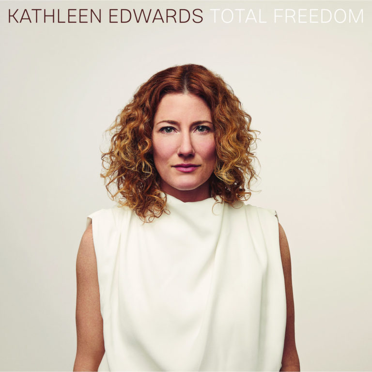 Porträt von Kathleen Edwards auf dem Cover ihres Albums „Total Freedom“ – die kanadische Singer-Songwriterin trägt ein schlichtes weißes Oberteil vor hellem Hintergrund.