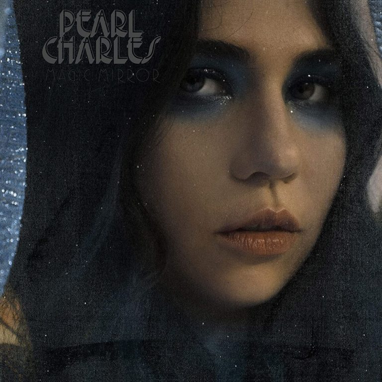 Albumcover von Pearl Charles – Magic Mirror: Nahaufnahme ihres Gesichts mit intensivem Blick, blauer Lidschatten, dunkler Hintergrund mit glitzernden Reflexen.