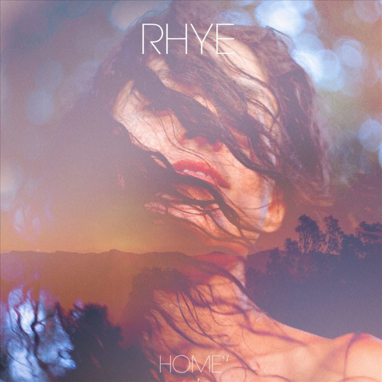 Albumcover von Rhye – Home: Verschwommenes, doppelt belichtetes Porträt einer Person mit vom Wind verwehtem Haar, kombiniert mit einer Landschaftssilhouette bei Sonnenuntergang.