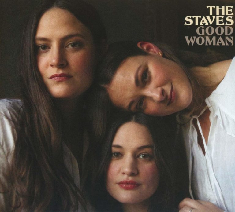 Die drei Schwestern von The Staves lehnen sanft aneinander, in natürlichem Licht, mit ruhigem Blick – ein intimes Porträt weiblicher Verbundenheit.