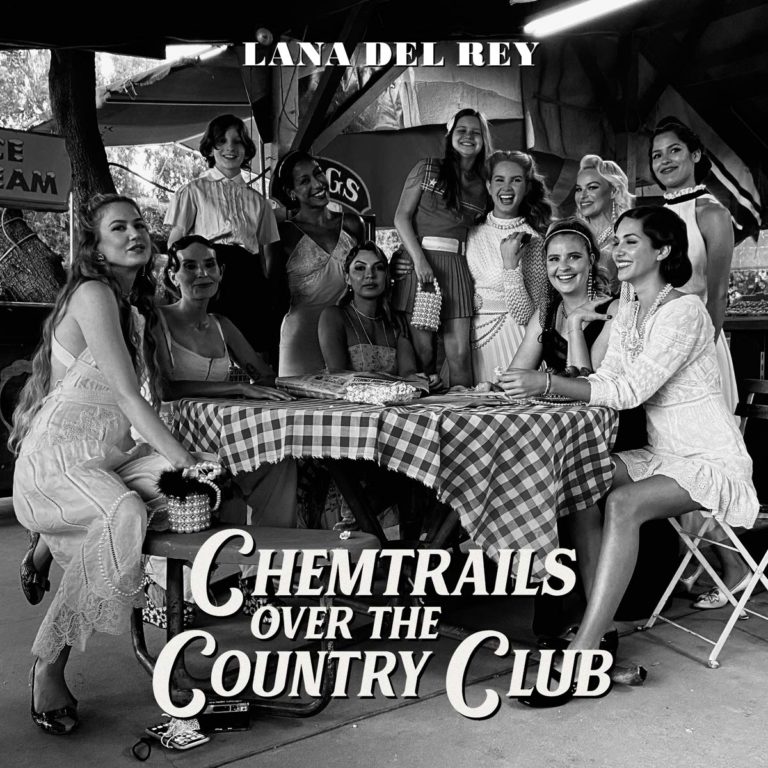 Schwarz-weißes Coverfoto von Lana Del Reys Album „Chemtrails Over the Country Club“, das eine Gruppe eleganter Frauen an einem Picknicktisch unter einem überdachten Landclub-Pavillon zeigt. Die Szene wirkt nostalgisch, inszeniert und zugleich intim – eine Mischung aus Hollywood-Glamour, Retro-Americana und geheimnisvoller Weiblichkeit.