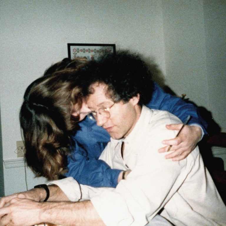Ein intimes Vintage-Foto zeigt zwei sich umarmende Personen in einem schlichten Raum – das Cover des Albums This Is Really Going To Hurt von Flyte.