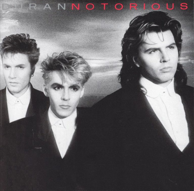 Schwarz-weißes Albumcover von Duran Duran mit drei Bandmitgliedern in eleganten Anzügen.