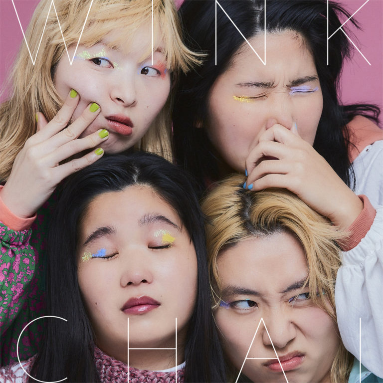Albumcover von CHAIs „WINK“ zeigt die vier Bandmitglieder in verspielten Posen vor rosa Hintergrund. Ihre bunten Lidschatten und Nägel betonen den poppig-exzentrischen Stil des Covers. Der Albumtitel „WINK“ und der Bandname „CHAI“ sind in dünner weißer Schrift über das Bild gelegt.