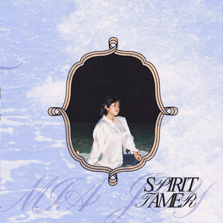 Albumcover von Mia Joys „Spirit Tamer“. In der Mitte ein eingerahmtes Porträt der Künstlerin im nächtlichen Freien, umgeben von einem himmelblauen, wolkigen Hintergrund mit geschwungenem Schriftzug.