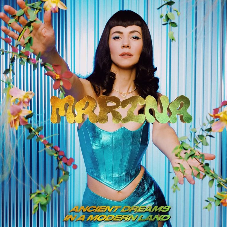 Marina in türkisfarbenem Korsett, zwischen Blumenranken vor blauem Hintergrund – Cover des Albums „Ancient Dreams in a Modern Land“.