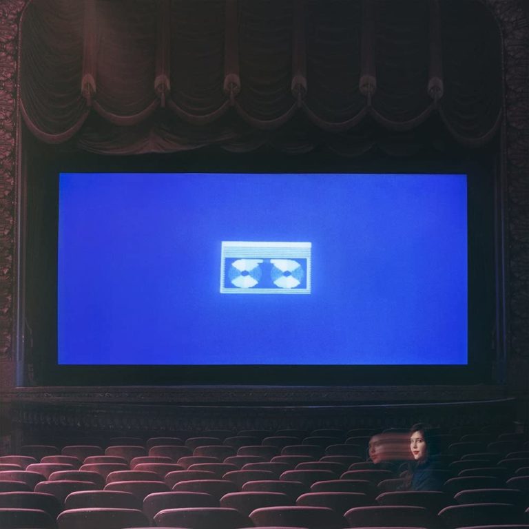 Das Albumcover von „Home Video“ von Lucy Dacus zeigt einen leeren Kinosaal mit einem blauen Bildschirm auf der Leinwand – nostalgisch und einsam zugleich.