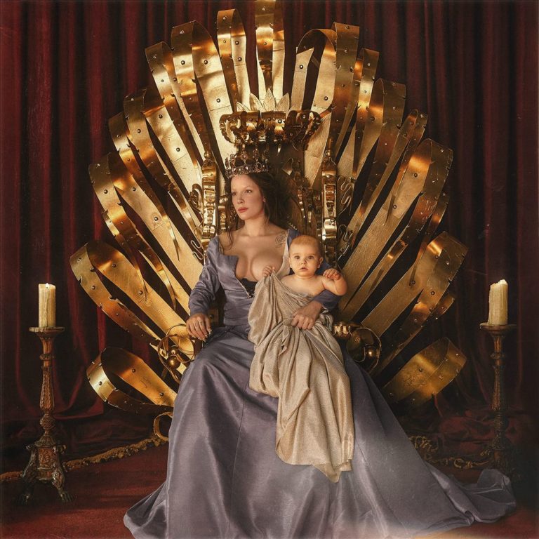 Halsey sitzt in einem königlichen, dramatisch ausgeleuchteten Thron aus goldenen Metallstreifen, ein Baby im Arm, Krone auf dem Kopf – eine majestätisch-moderne Mutterikone zwischen Macht und Verletzlichkeit.