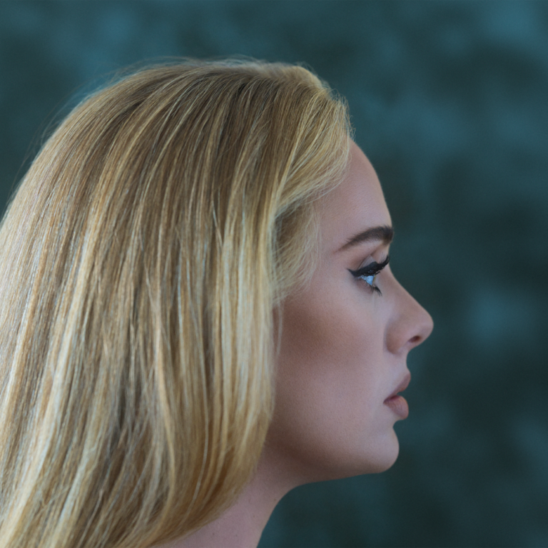 Profilaufnahme von Adele mit strengem Seitenblick vor türkisfarbenem Hintergrund – ein stiller, intimer Moment voller Stärke und Verletzlichkeit.
