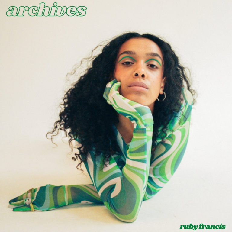 Ruby Francis liegt entspannt in Retro-Muster-Body auf weißem Grund – verträumt und direkt, Cover ihres Neo-Soul-Albums Archives.