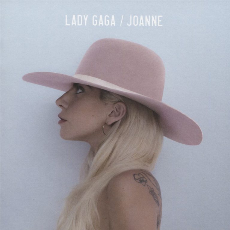 Lady Gaga im Profil mit blondem Haar und rosa Hut vor graublauem Hintergrund – minimalistisches Cover des Albums „Joanne“.