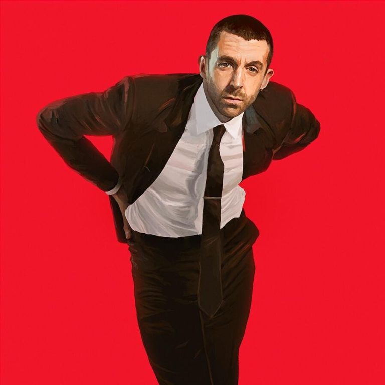 Albumcover von Miles Kane – Change the Show: Der Musiker im Anzug vor knallrotem Hintergrund, in schräger Pose, zwischen Retro-Charme und Pop-Attitüde.