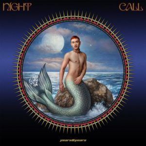 Albumcover von Night Call zeigt Olly Alexander als Meermann auf einem Felsen im Mondschein – queer, surreal, mythologisch aufgeladen und popkulturell verspielt.