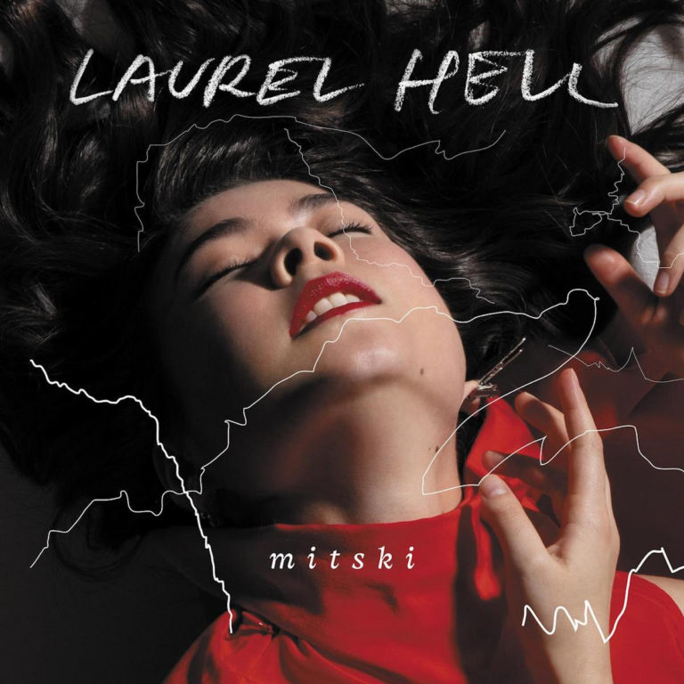 Albumcover von Mitski – eine Frau in rotem Kleid liegt mit geschlossenen Augen da, überlagert von weißen Linien wie Bruchkanten auf einer Landkarte – sinnlich, zerrissen, entrückt.