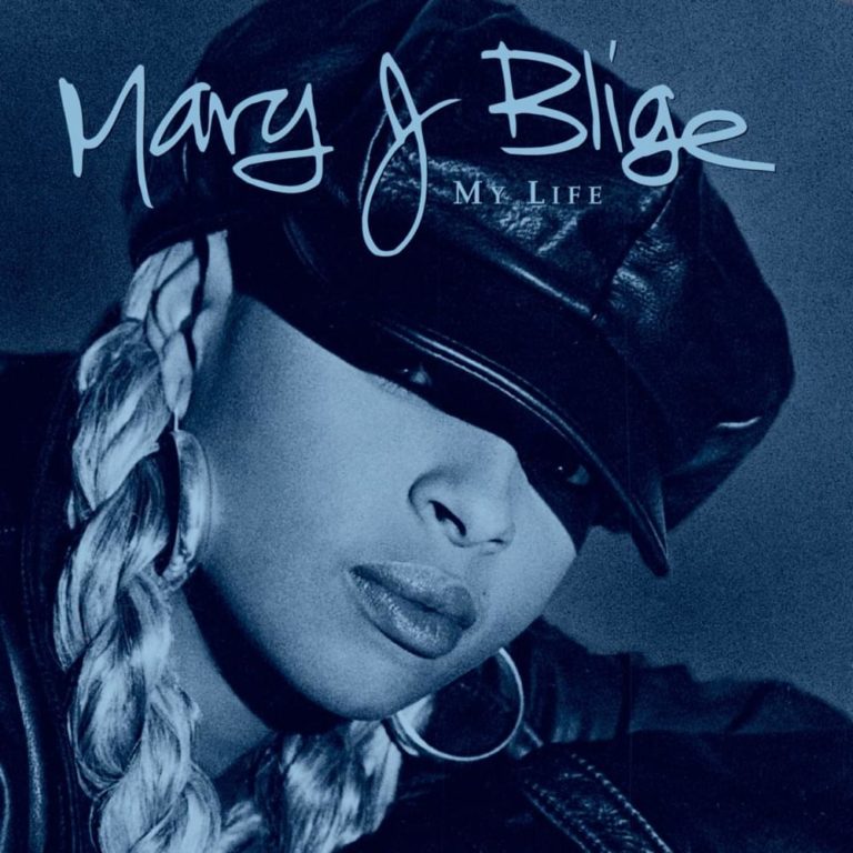 Porträt von Mary J. Blige mit Lederkappe und Zöpfen auf blauem Hintergrund.