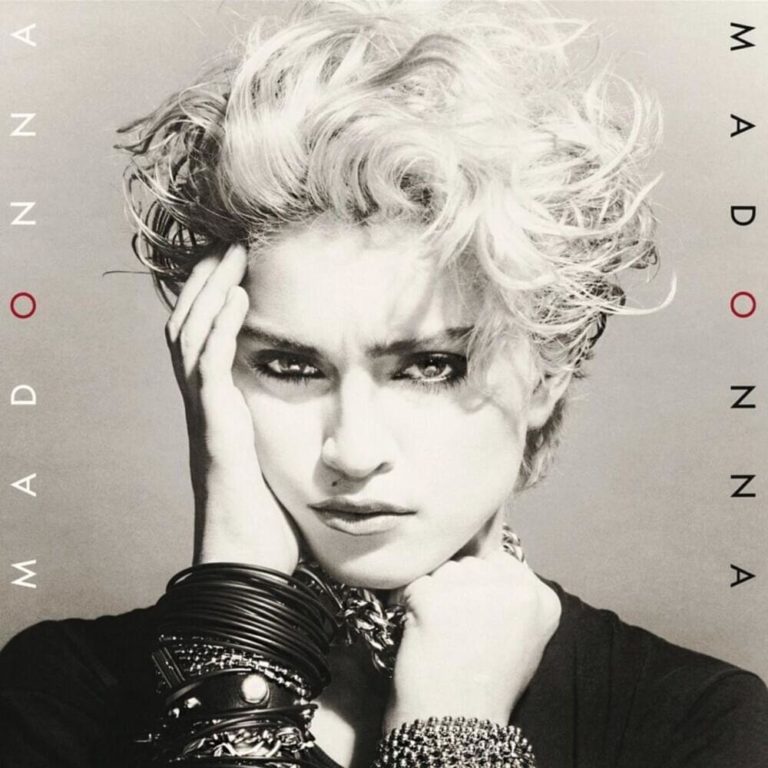 Schwarz-weißes Albumcover von Madonna mit kurzem, lockigem Haar und auffälligem Schmuck.