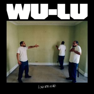 Cover zu Wu-Lus „LOGGERHEAD“: Der Künstler erscheint dreifach in einem leeren, grün tapezierten Zimmer – einmal anklagend, einmal abgewandt, einmal mit verletztem Blick. Die Szene wirkt konfrontativ und zerrissen, ein Spiegel innerer Kämpfe und gesellschaftlicher Entfremdung.