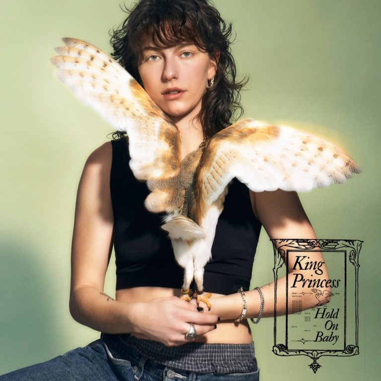 King Princess hält eine Schleiereule vor der Brust, deren Flügel sich weit öffnen – das Cover zu „Hold On Baby“ verbindet Natur und Sensibilität mit ikonischer Ruhe.