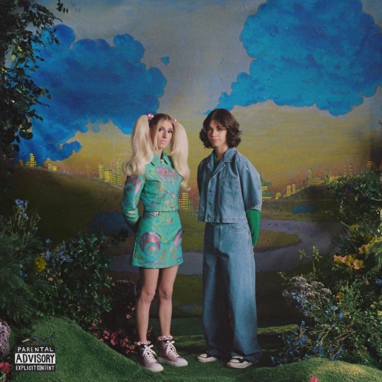Das Cover zeigt DOMi & JD BECK in surrealer Gartenszenerie, in verspielten Outfits und vor einem gemalten Himmel – zwischen Retro-Fantasy und Kinderzimmerästhetik.