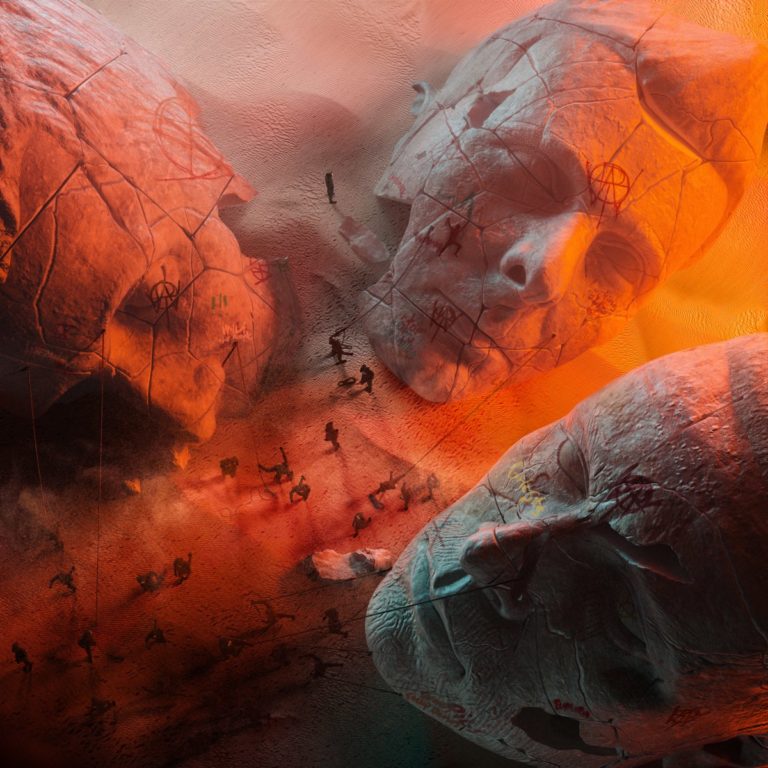 Cover des Albums „Will of the People“ von Muse mit drei zerbrochenen Steinköpfen im Wüstensand, umgeben von Flammen, Symbolen und Miniaturfiguren.