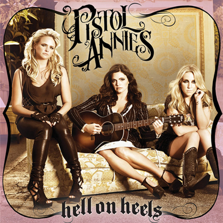 Drei Frauen sitzen auf einem Sofa, eine hält eine Gitarre, im Hintergrund der Schriftzug Pistol Annies.
