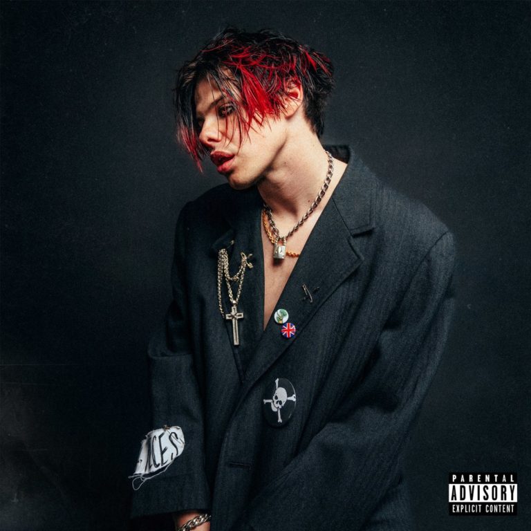 Porträt von YUNGBLUD mit rotschwarzen Haaren und offenem Sakko vor dunklem Hintergrund – Cover seines selbstbetitelten Albums von 2022.