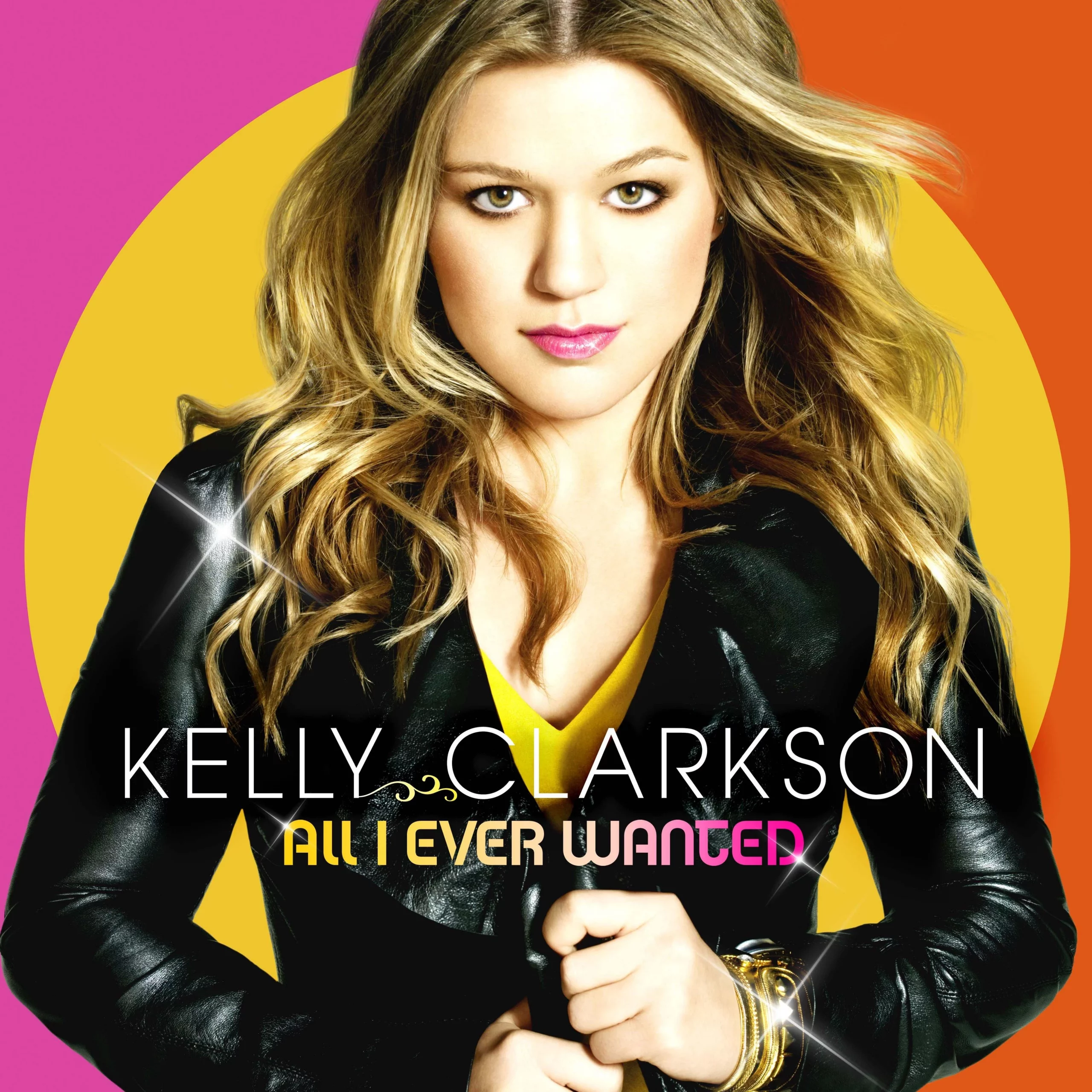 Kelly Clarkson in schwarzer Jacke vor buntem Hintergrund.