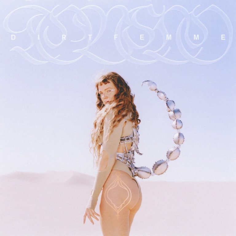 Tove Lo steht im Wüstensand, trägt einen körperbetonten Anzug mit Skorpion-Schwanz und blickt über die Schulter – futuristisch, feminin und furchtlos.