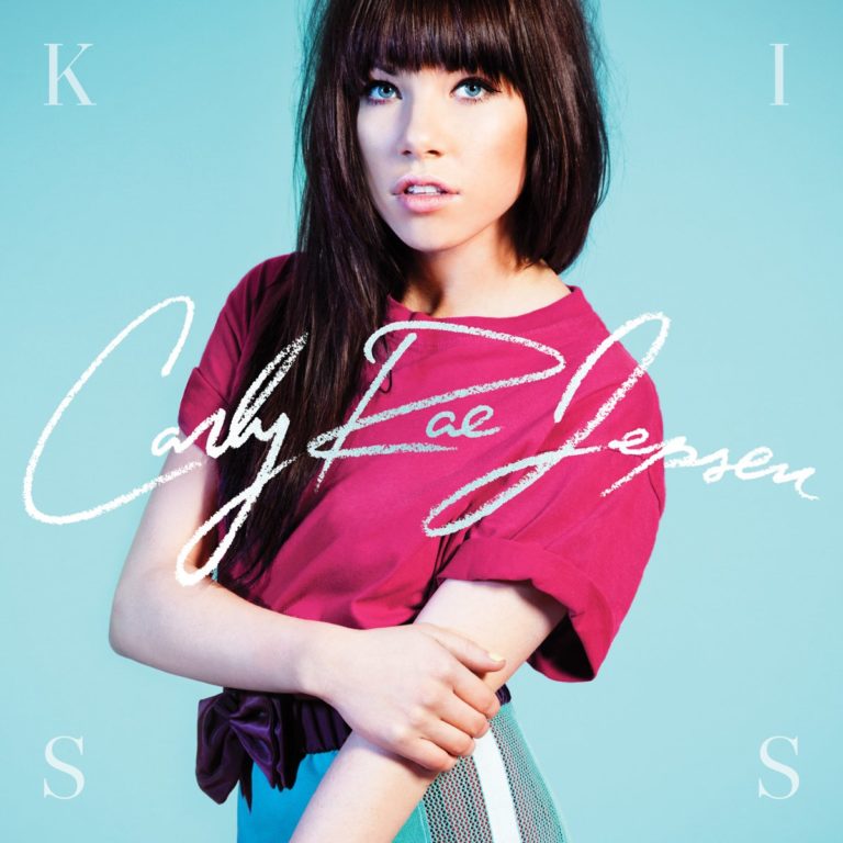 Frau mit langen Haaren in rotem Oberteil vor blauem Hintergrund, Schriftzug Carly Rae Jepsen.