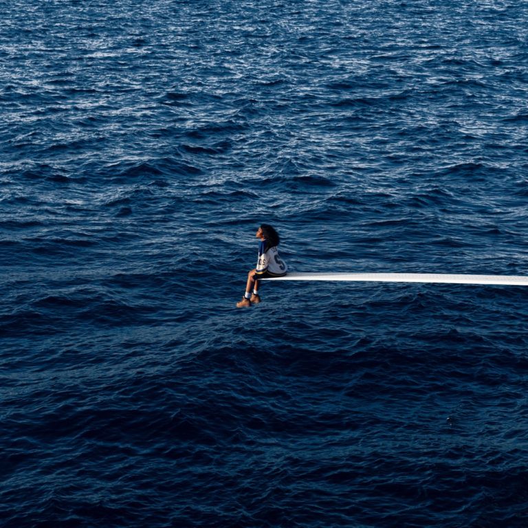 Das Cover von SOS zeigt SZA einsam auf einem Sprungbrett über offenem Ozean – eine Hommage an Prinzessin Dianas ikonisches Yachtfoto und zugleich ein visuelles Sinnbild für Isolation, Kontrolle und emotionale Weite.
