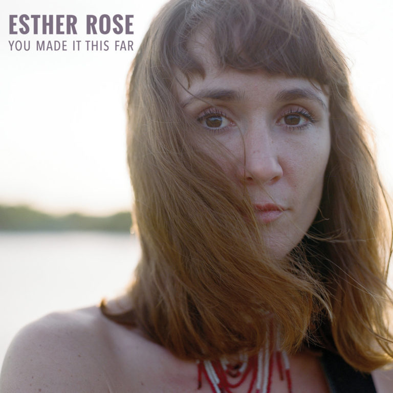 Nahaufnahme von Esther Rose mit Blick in die Kamera, im Hintergrund unscharfe Natur.