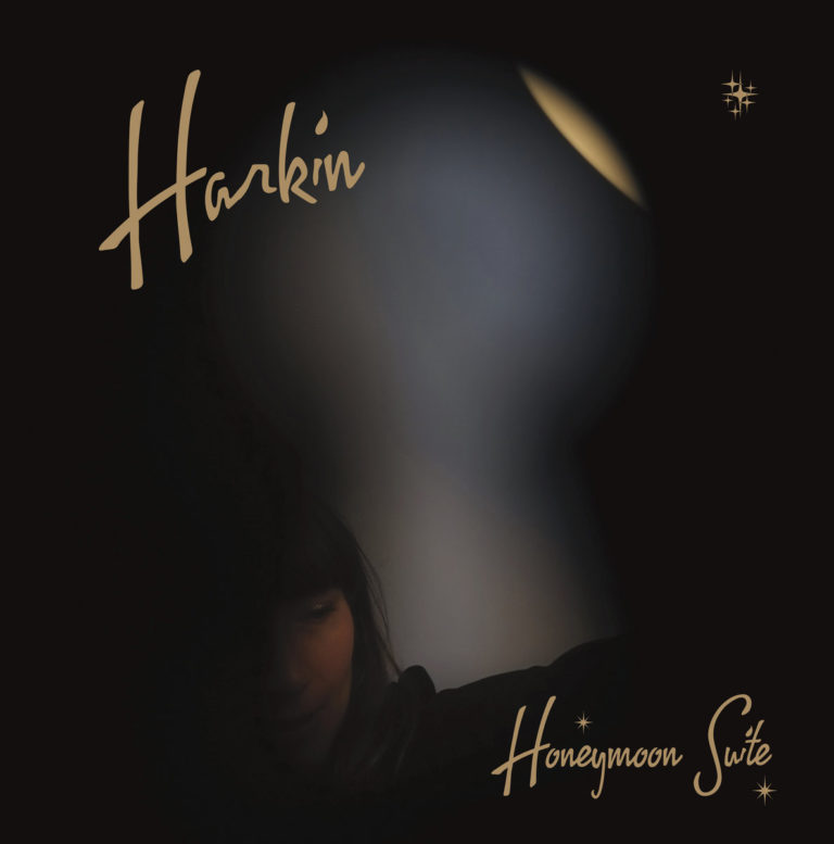 Ein verschwommenes Schlüssellochlicht fällt auf das geheimnisvoll angedeutete Gesicht von Harkin. Das Cover der „Honeymoon Suite“ versprüht introvertierte Intimität, Sehnsucht und nächtliche Eleganz – ein Blick in ein verschlossenes Zimmer voller Synthpop-Melancholie.