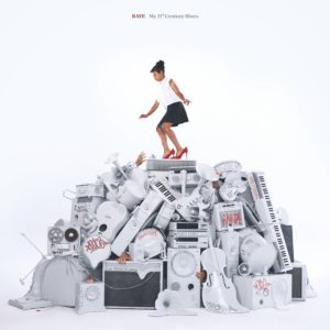 Cover des Albums „My 21st Century Blues“ von RAYE: Sie steht in roten High Heels auf einem Haufen weißer Instrumente und Elektronikgeräte
