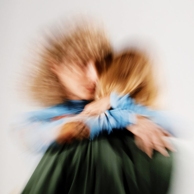 Albumcover von „Pollen“ von Tennis: Zwei Menschen umarmen sich unscharf in einer Bewegungsunschärfe, die sie wie verwischte Erinnerungen erscheinen lässt.