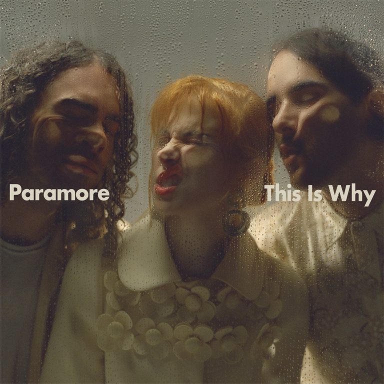 Paramore auf dem Cover von „This Is Why“: Drei Bandmitglieder drücken ihre Gesichter humorvoll gegen eine beschlagene Glasscheibe, auf der Kondenswasser läuft.