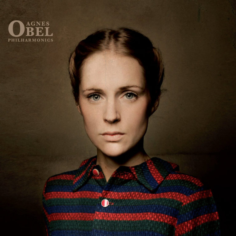 Porträt von Agnes Obel in gestreifter Bluse vor neutralem Hintergrund.