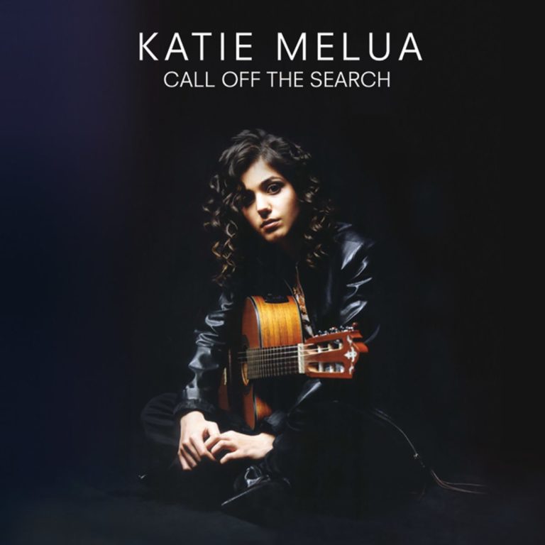 Katie Melua sitzt mit Gitarre in dunkler Umgebung.