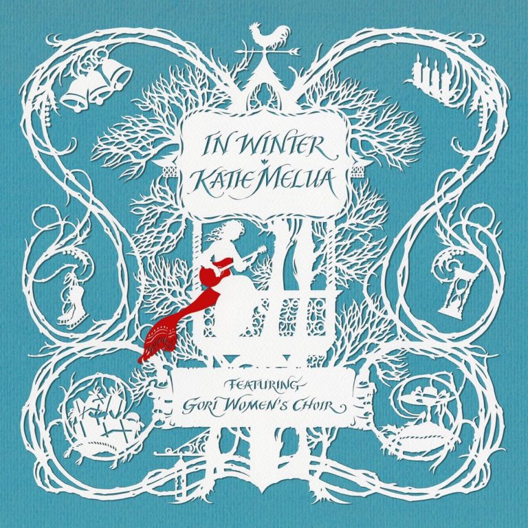Papierkunst mit winterlichen Motiven, zeigt eine Frau mit Gitarre, Bäume und Glocken auf blauem Hintergrund.